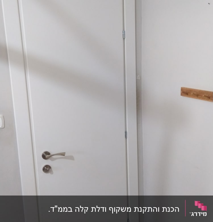 דלת לבנה עם ידית מתכת בחדר פנימי